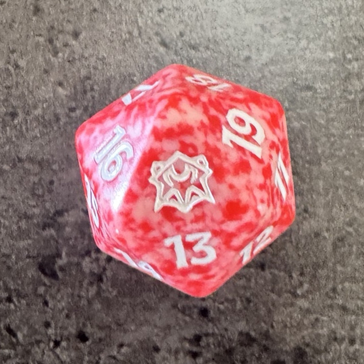 Dé Magic Dark Ascension / Obscure Ascension, D20 rouge et blanc marbré — photo réelle. / Dark Ascension red-and-white marbled Spindown D20 — actual photo.